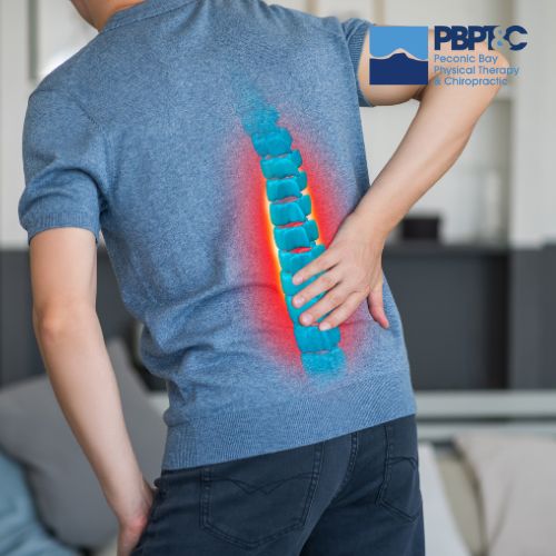 Person holding lower back, with a highlighted spine illustration indicating pain, suggesting discomfort or back injury. Peconic Bay Physical Therapy & Chiropractic logo in the corner.